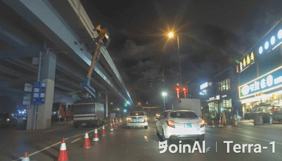 JoinAI Terra generated video frame showing a nighttime road scene 10 with multiple vehicles and traffic cones.